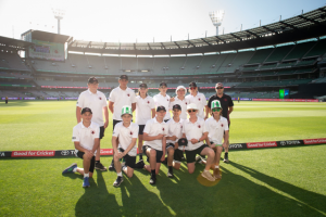 Young cricketers enjoy a lap of honour around the MCG